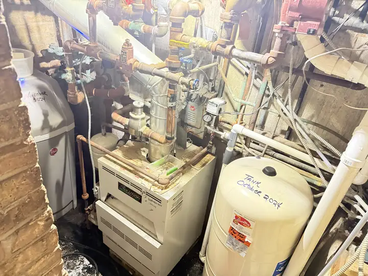 Boiler in a basement mechanical room with an expansion tank and supply piping