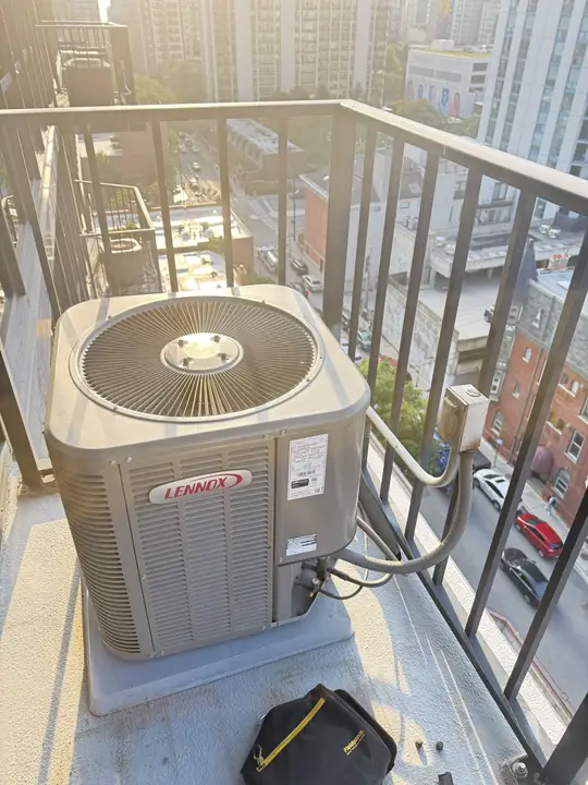 Lennox air conditioner condenser on a high-rise balcony overlooking a Chicago street