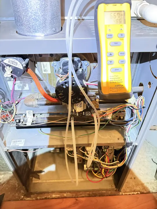 Dual-port manometer connected to a gas furnace to check gas pressure