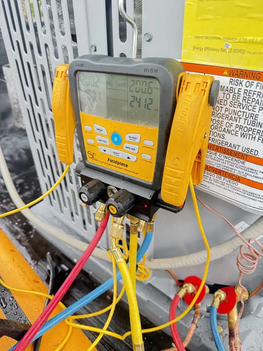 Digital refrigerant manifold gauge set connected to an outdoor unit during a nitrogen pressure test