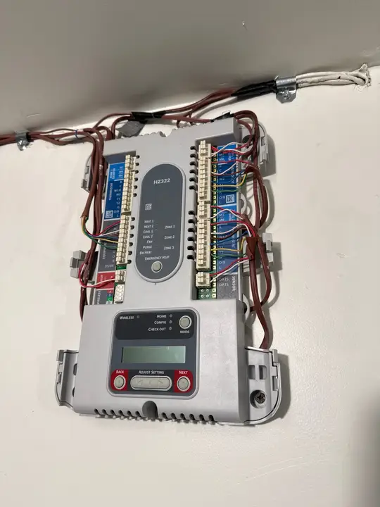 Zone control panel wired to three zone dampers on a basement wall